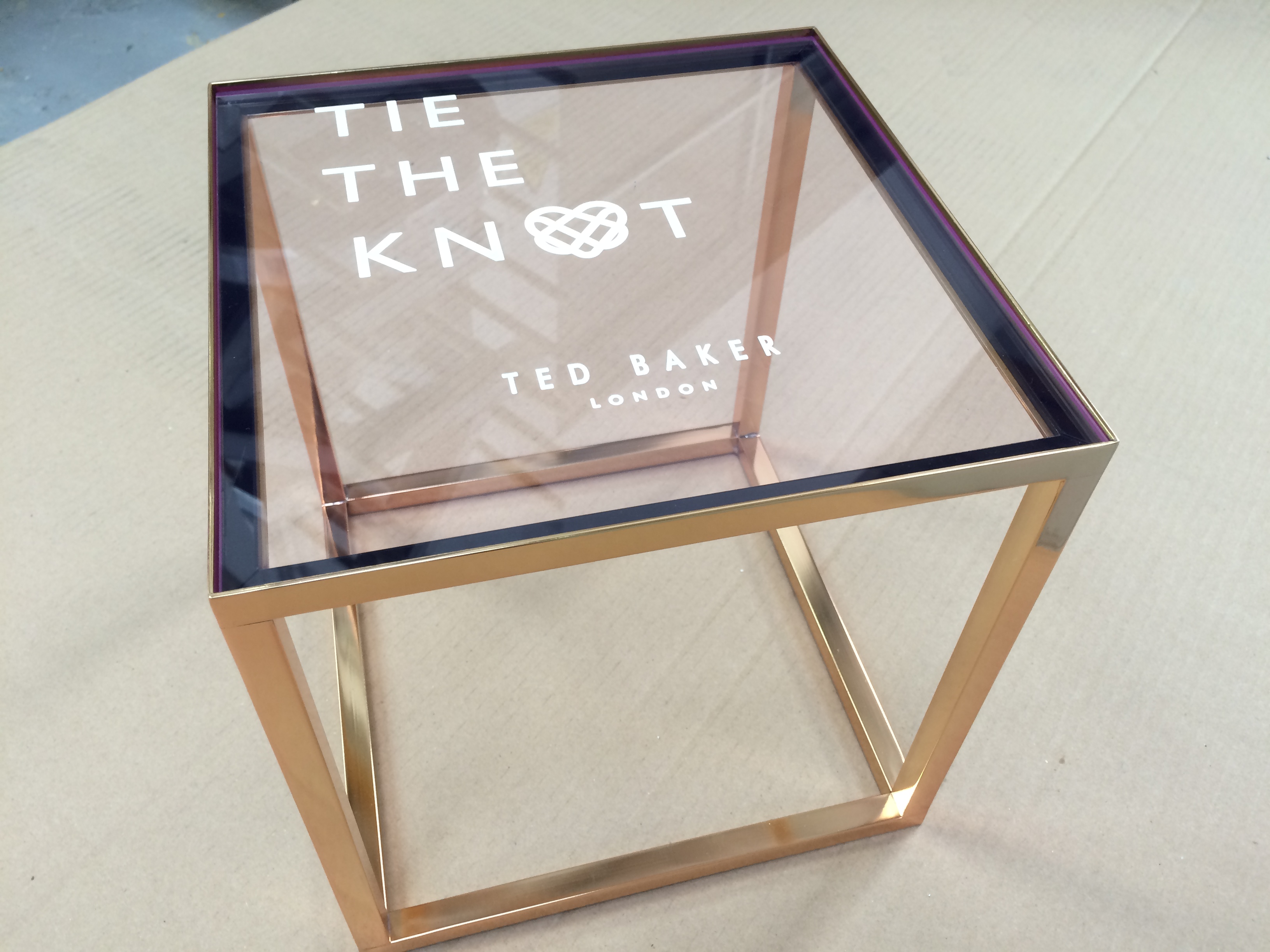 Ted Baker Tie The Knot Footwear Display. Welded steel stand, plated in gold finish with engraved and infilled Fluorescent pink edge clear acrylic.